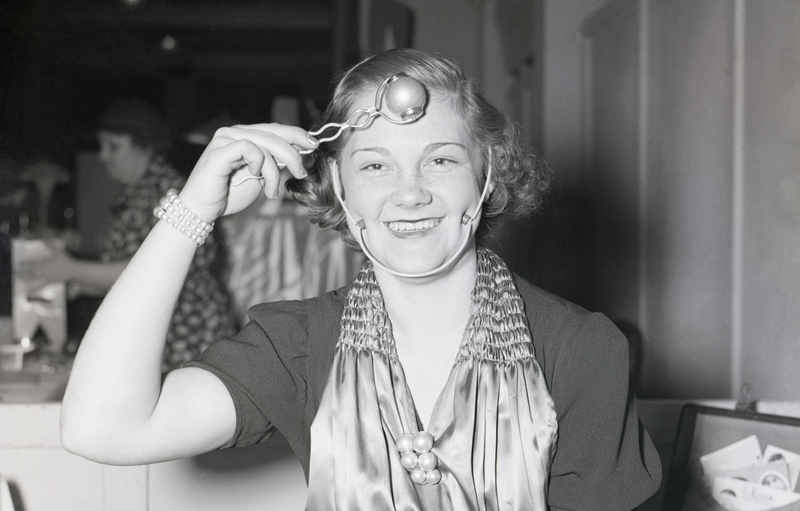 4/9/1938- Chicago, IL: A young woman demonstrates a ‘dimple’ machine at the Inventor’s Congress in Chicago.